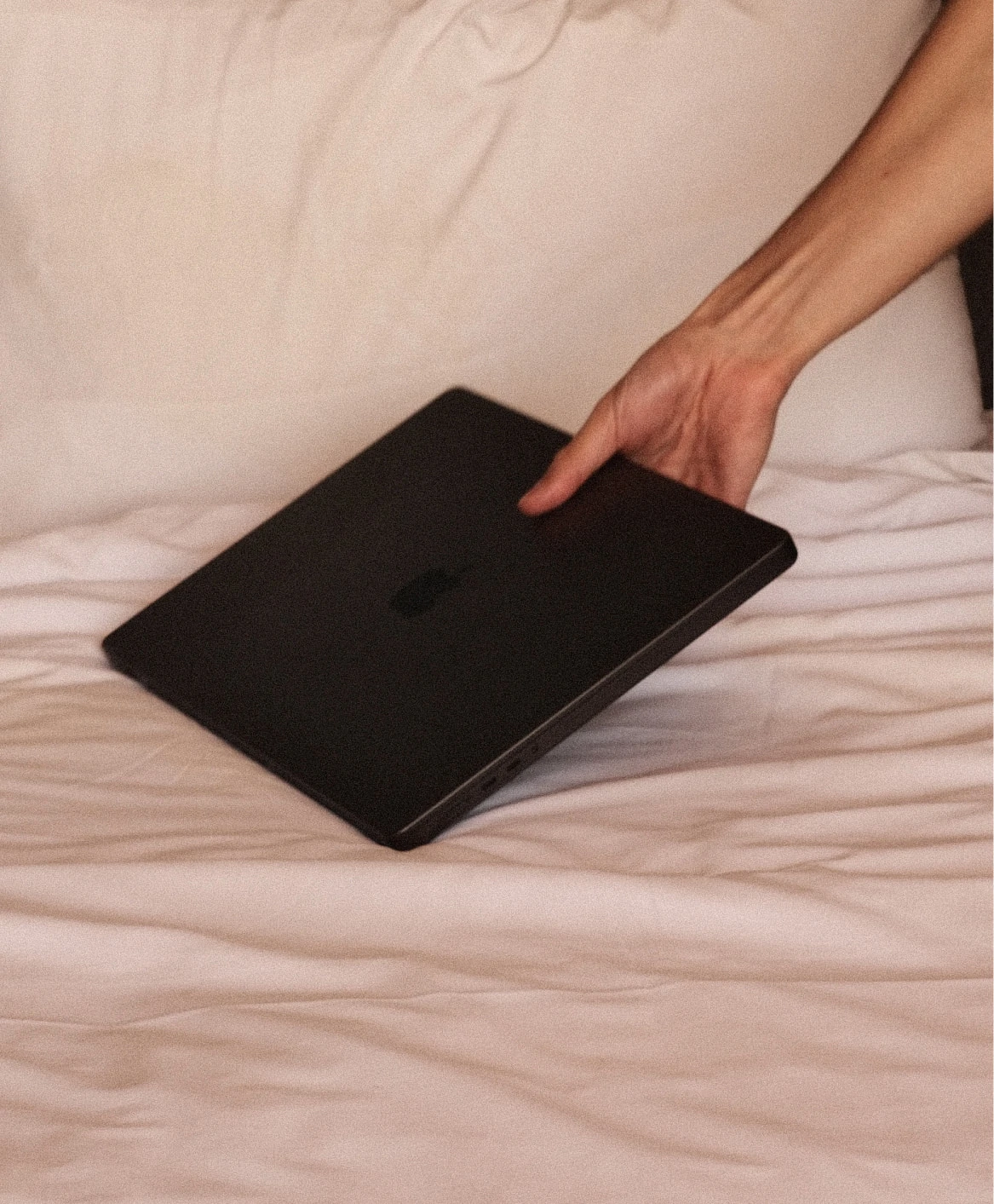 Holding a MacBook on the bed